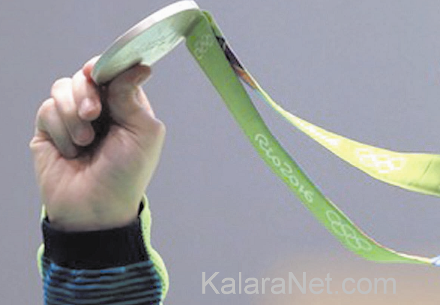Main levée avec une médaille olympique  à Rio2016